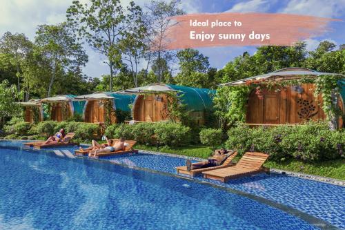 a group of people laying on lounge chairs by a swimming pool at Phu Quoc Valley Sen Bungalow in Phu Quoc