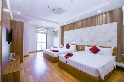 een slaapkamer met 2 bedden en een grote muur bij Anh Thảo Hotel Quy Nhơn in Quy Nhon