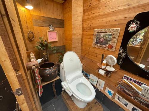 a bathroom with a toilet in a wooden room at Mizuno Sang's Tree House 