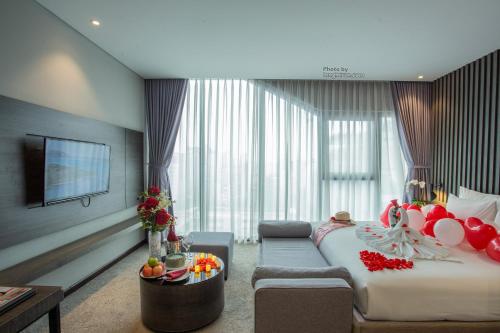a hotel room with a large bed and a television at Grand Ocean Luxury Boutique - Infinity Rooftop Pool in Da Nang