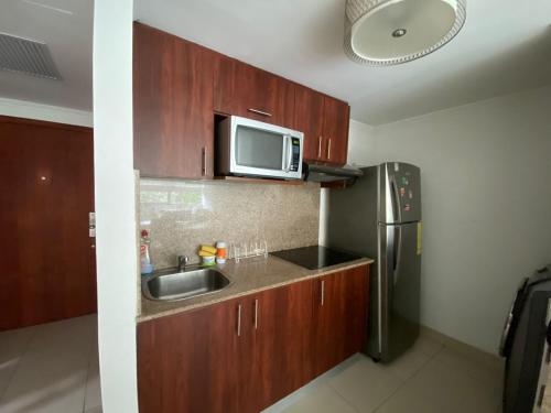 una pequeña cocina con fregadero y microondas en Departamento , Infinity Host, en Guayaquil
