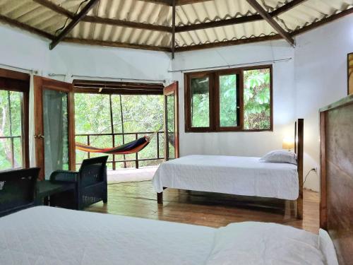 1 dormitorio con 2 camas y hamaca. en Isla Cébaco en Isla Cebaco 