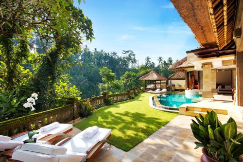 a backyard with a swimming pool and a house at Viceroy Bali in Ubud