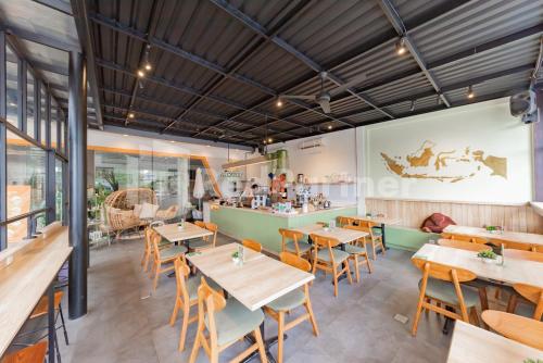 a restaurant with tables and chairs and a bar at Hotel Alqueby Mitra RedDoorz in Bandung