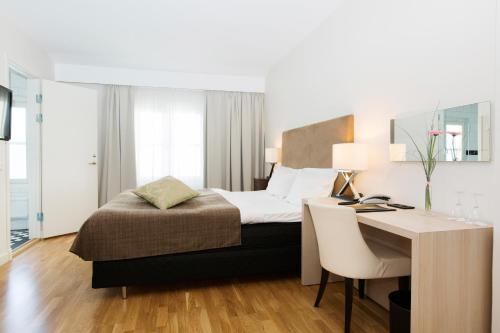 a bedroom with a bed and a desk with a desk at Elite Stadshotellet Karlstad, Hotel & Spa in Karlstad