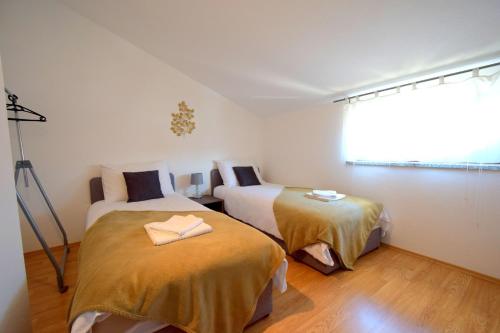a bedroom with two beds with yellow sheets and a window at Apartment Paula in Njivice
