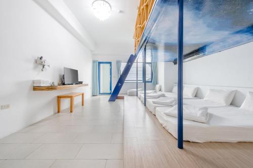 a living room with white walls and blue beams at White Lighthouse in Xiaoliuqiu