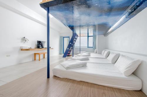 a row of beds in a room with a ceiling at White Lighthouse in Xiaoliuqiu