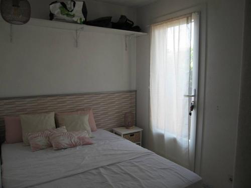 um quarto com uma cama branca e uma janela em Appartement Saint-Cyprien, 2 pièces, 4 personnes - FR-1-106-31 em Saint-Cyprien