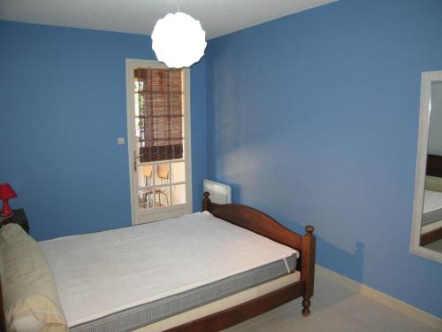 une chambre bleue avec un lit et une fenêtre dans l'établissement Villa 4 pièces, 10 couchages, jardin, terrasses, à 900m de la plage, Saint-Cyprien - FR-1-106-35, à Saint-Cyprien