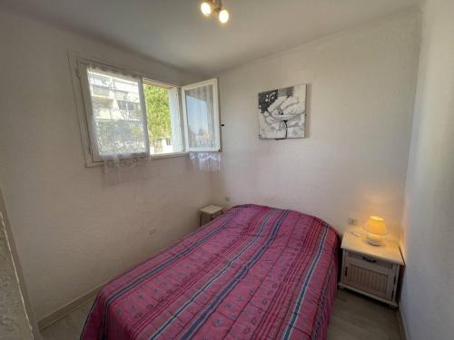 ein Schlafzimmer mit einem Bett, einem Tisch und zwei Fenstern in der Unterkunft Appartement Saint-Cyprien, 2 pièces, 4 personnes - FR-1-106-30 in Saint-Cyprien