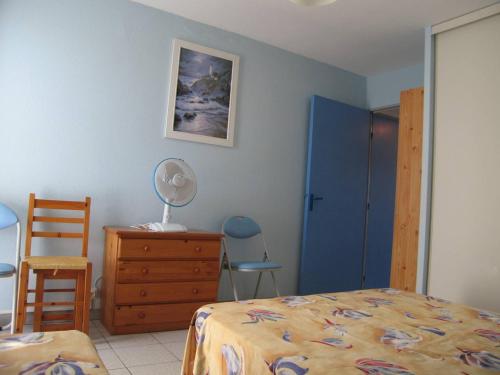 une chambre avec un lit, une commode et une chaise dans l'établissement Appartement T2 avec 5 couchages, piscine, tennis, proche plage et port, animaux admis - Saint-Cyprien - FR-1-106-47, à Saint-Cyprien