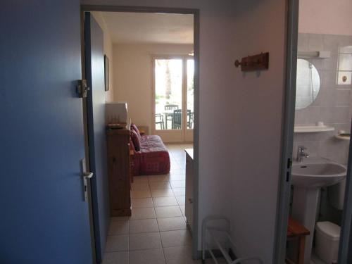 La salle de bains est pourvue d'une porte s'ouvrant sur une chambre avec un lavabo. dans l'établissement Appartement T2 avec 5 couchages, piscine, tennis, proche plage et port, animaux admis - Saint-Cyprien - FR-1-106-47, à Saint-Cyprien
