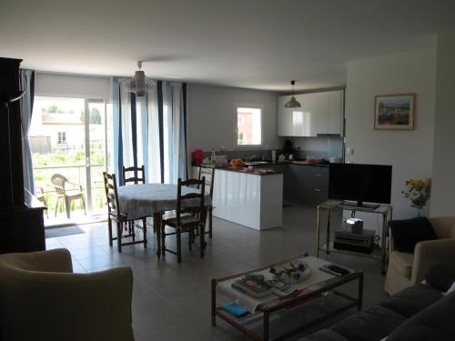 un salon avec une table et une cuisine dans l'établissement Charmante villa F4 avec jardin, terrasse et garage – St Cyprien Village, proche commerces et plage - FR-1-106-40, à Saint-Cyprien