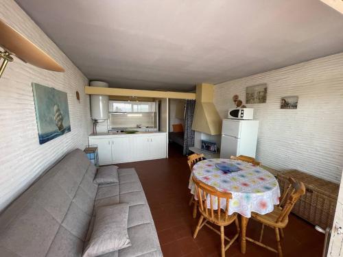 - une cuisine et une salle à manger avec une table et un canapé dans l'établissement Appartement 2 pièces face plage avec loggia, parking sécurisé et Wifi - Saint-Cyprien - FR-1-106-46, à Saint-Cyprien