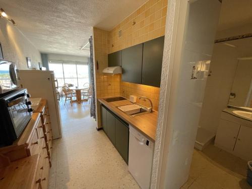 une cuisine avec un évier et un plan de travail dans l'établissement Charmant studio climatisé avec wifi et parking à 100m de la plage - FR-1-106-51, à Saint-Cyprien