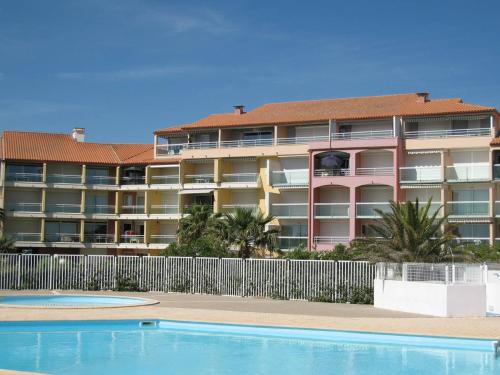 un immeuble d'appartements avec une piscine en face dans l'établissement T3 avec piscine, parking, animaux admis, Saint-Cyprien - FR-1-106-52, à Saint-Cyprien