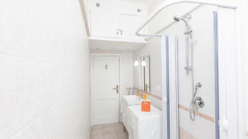 y baño blanco con lavabo y ducha. en Rental in Rome Sistina View, en Roma