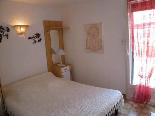 a bedroom with a white bed and a window at Villa Saint-Cyprien, 3 pièces, 6 personnes - FR-1-106-57 in Saint-Cyprien