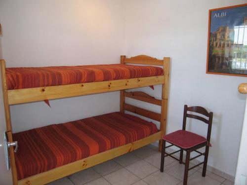 - une chambre avec 2 lits superposés et une chaise dans l'établissement 3 pièces avec piscine à Saint-Cyprien - 6 couchages - FR-1-106-59, à Saint-Cyprien