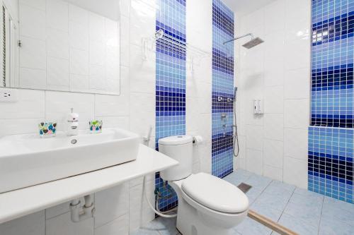 a bathroom with a toilet and a sink and blue tiles at White Lighthouse in Xiaoliuqiu