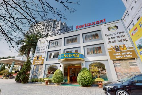 a large white building with a snowman sign on it at Sao Mai Hotel in Thanh Hóa