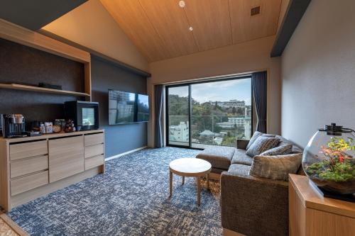 a living room with a couch and a large window at Hatago in Kobe