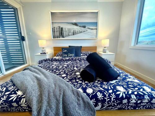 ein Schlafzimmer mit einem Bett mit einer blauen und weißen Decke in der Unterkunft Summer Salt Beach House in Ulladulla