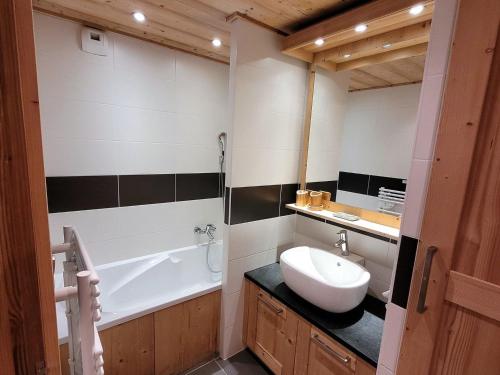 a bathroom with a sink and a bath tub at Confortable T4, terrasse, parking et Wi-Fi, au centre et proche pistes - FR-1-598-129 in Les Gets