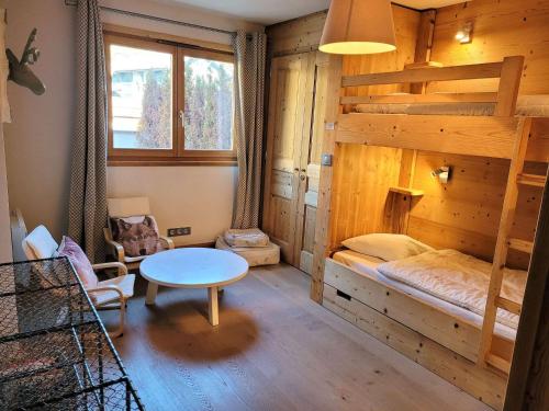 a room with a bunk bed and a table at Confortable T4, terrasse, parking et Wi-Fi, au centre et proche pistes - FR-1-598-129 in Les Gets
