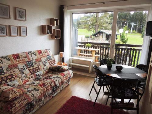un salon avec un canapé, une table et une fenêtre dans l'établissement Studio ski au pied rénové, balcon, piscine, parking - FR-1-598-131, aux Gets
