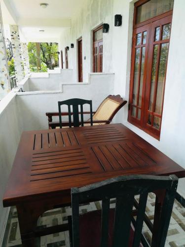 a wooden table and chairs on a porch at Aurora View Inn in Haputale