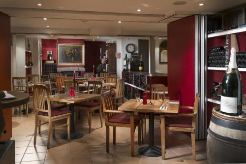 a restaurant with tables and chairs and a bottle of wine at Hotel Baseler Hof in Hamburg