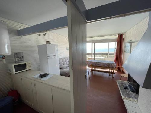 une cuisine avec un réfrigérateur et un salon dans l'établissement Appartement T2 avec 6 couchages, animaux admis, parking, wifi - FR-1-106-75, à Saint-Cyprien