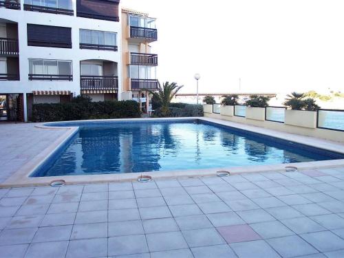 une piscine devant un immeuble dans l'établissement Studio cabine avec piscine à Saint-Cyprien, plage à 50m - FR-1-106-76, à Saint-Cyprien