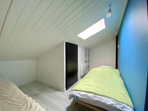 - une chambre mansardée avec un lit et une lucarne dans l'établissement Appartement cosy avec piscine chauffée proche mer et centre – rénové et calme - FR-1-231-280, à Bretignolles-sur-Mer