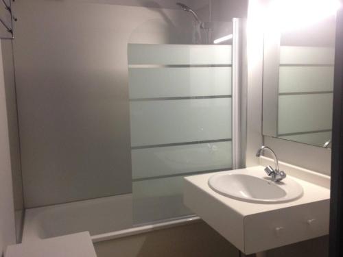 une salle de bain blanche avec un lavabo et une douche dans l'établissement Appartement Charmant avec Piscine, Tennis et Parking à Capbreton, Proche Océan et Port de Plaisance - FR-1-239-880, à Capbreton