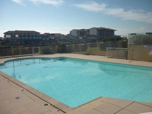 - une grande piscine bleue au-dessus d'un bâtiment dans l'établissement Appartement Charmant avec Piscine, Tennis et Parking à Capbreton, Proche Océan et Port de Plaisance - FR-1-239-880, à Capbreton