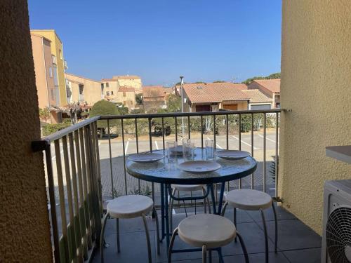 un balcon avec une table et des chaises sur un balcon dans l'établissement Appartement 2 Pièces/Cabine avec Balcon et Parking Privé – 200m Plage, Climatisé, Animaux Acceptés - FR-1-229D-116, à Fleury