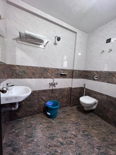 a bathroom with a sink and a toilet and a mirror at Hotel Mangalore Stay INN in Mangalore