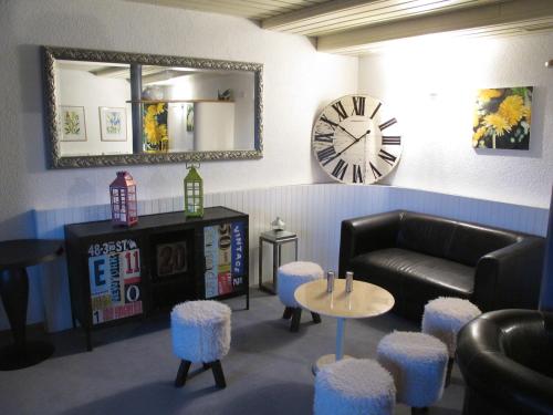 a living room with a couch and a clock and stools at Hotel du Lac in Crans-Montana