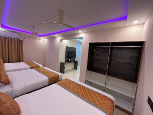 a hotel room with two beds and a tv at Hotel Mangalore Stay INN in Mangalore