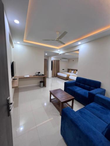 a living room with a blue couch and a table at Hotel Mangalore Stay INN in Mangalore