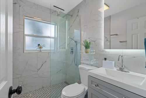 a bathroom with a toilet and a sink and a shower at Upscale 2br House Wprivate Yard & Parking in St. Petersburg