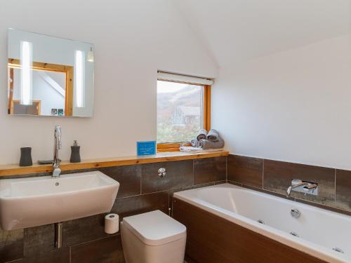 a bathroom with a tub and a toilet and a sink at Seascape in Fiskavaig