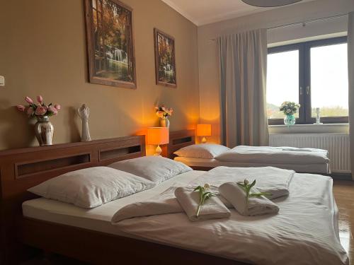 twee bedden in een slaapkamer met bloemen erop bij Villa Dudziak in Słubice