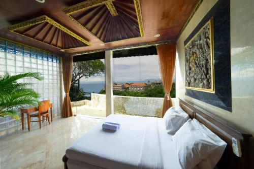 a bedroom with a bed with a view of the ocean at Uluwatu Mansion Villas in Uluwatu