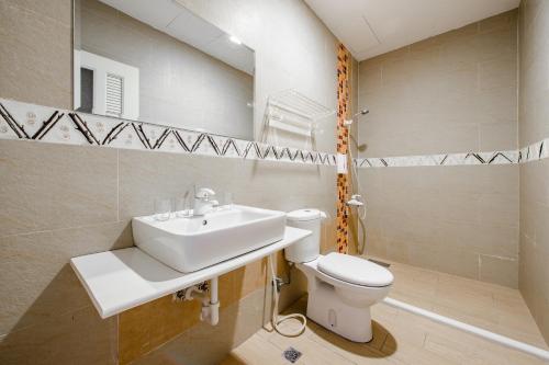 a bathroom with a sink and a toilet and a mirror at White Lighthouse in Xiaoliuqiu