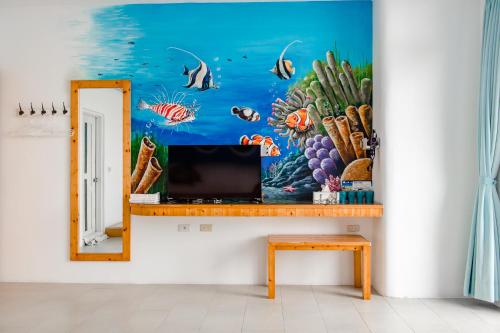 a mirror on a wall with a painting of the ocean at White Lighthouse in Xiaoliuqiu