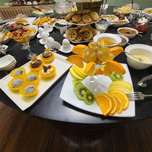 a table topped with plates of fruit and desserts at Sangzor Boutique Hotel in Samarkand